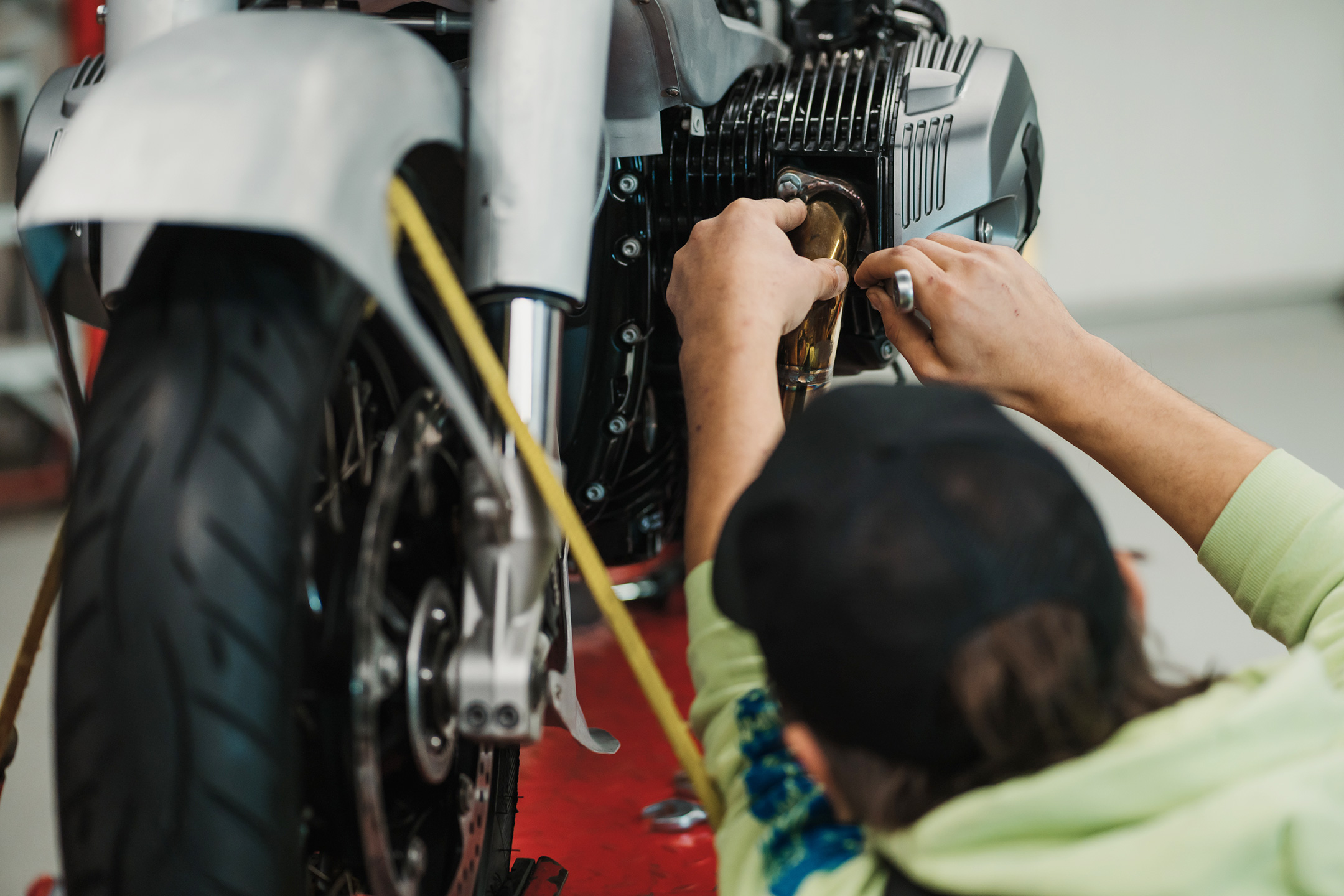 Man fixing a motorcycle in a modern workshop