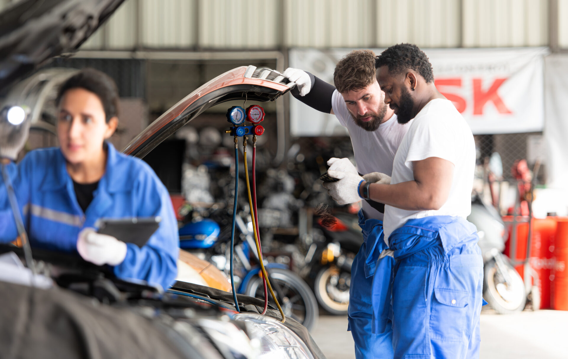 Car mechanic working in an auto repair shop, inspecting the oper