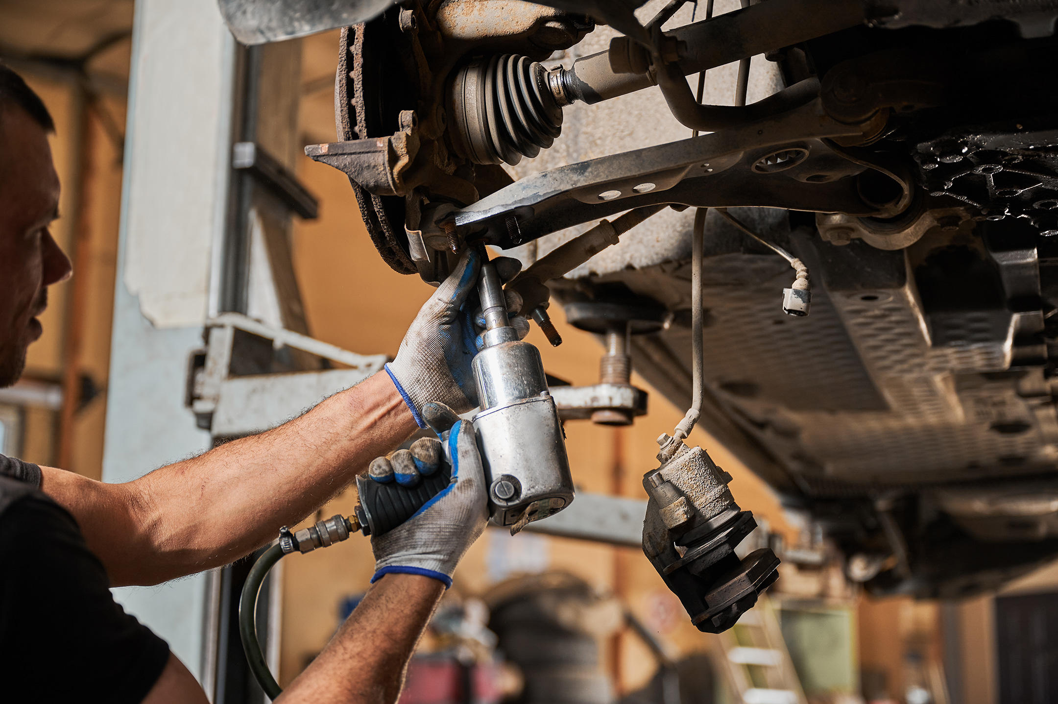 Mechanic, engineer servicing car in garage, auto center.